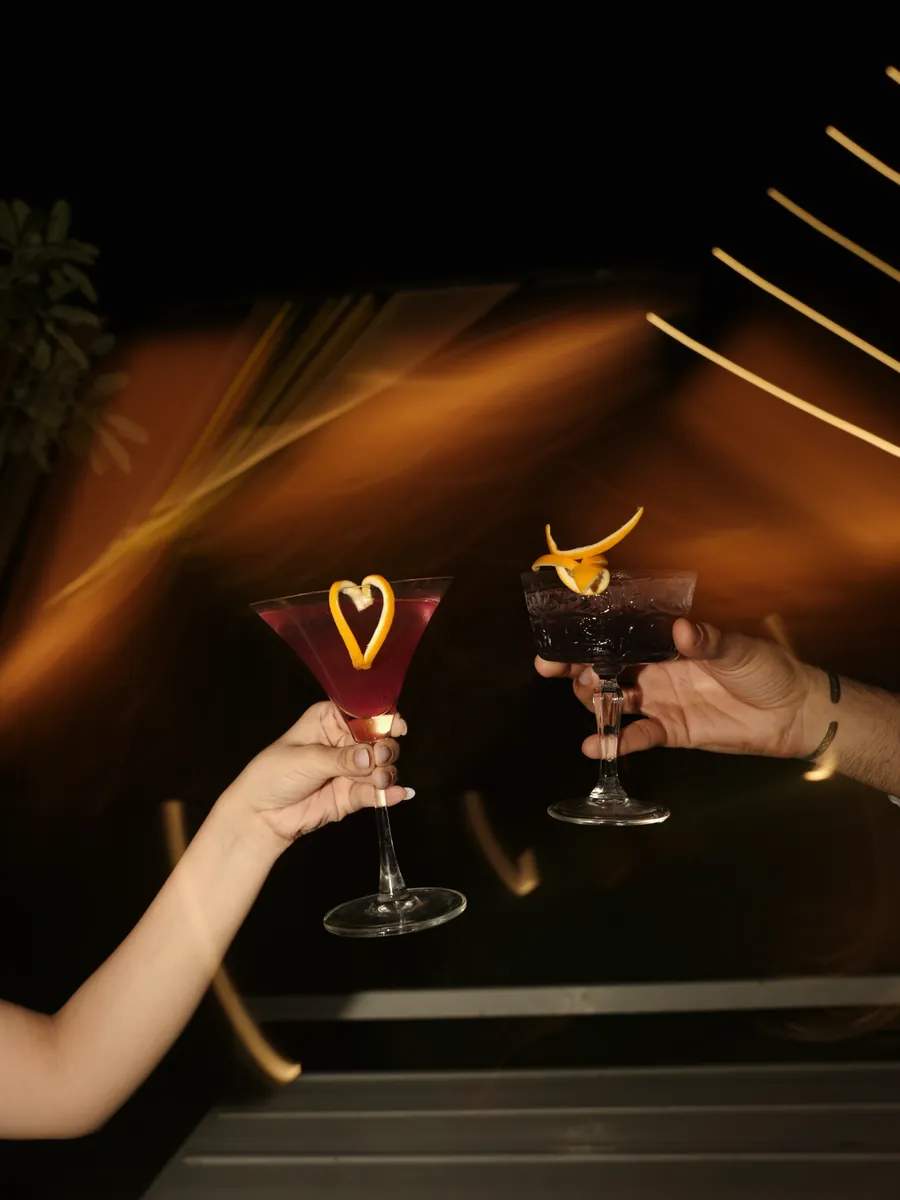 Two cocktails raised in a toast at a Centre Point bar